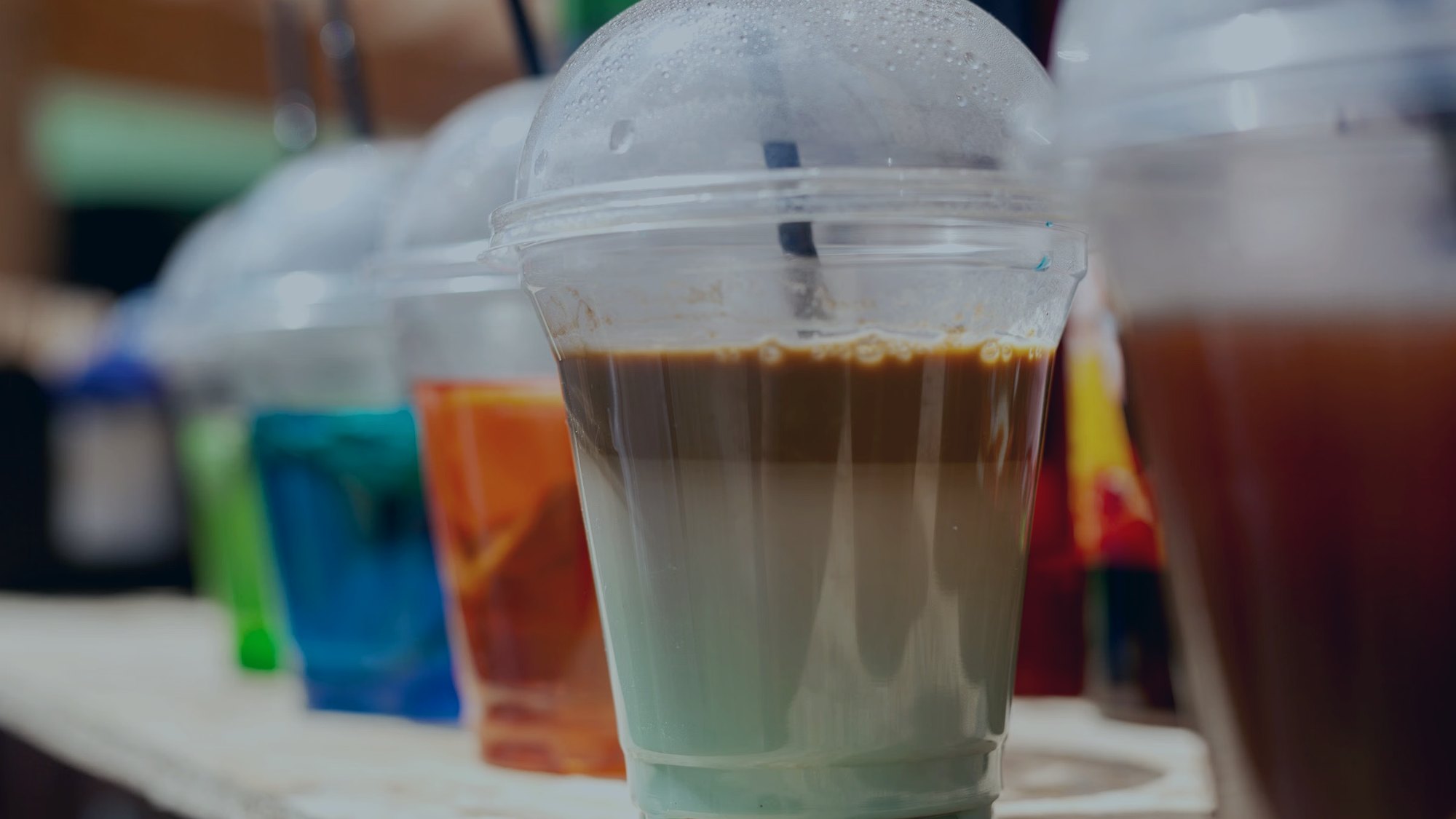 Printed and transparent cups with peelable lidding film on a production table